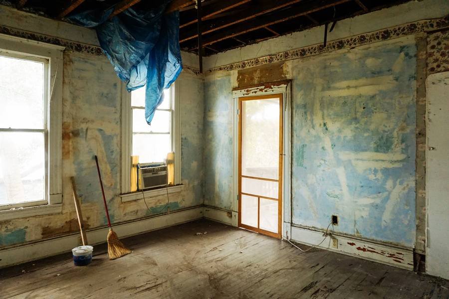 An empty room with peeling walls in a vacant house