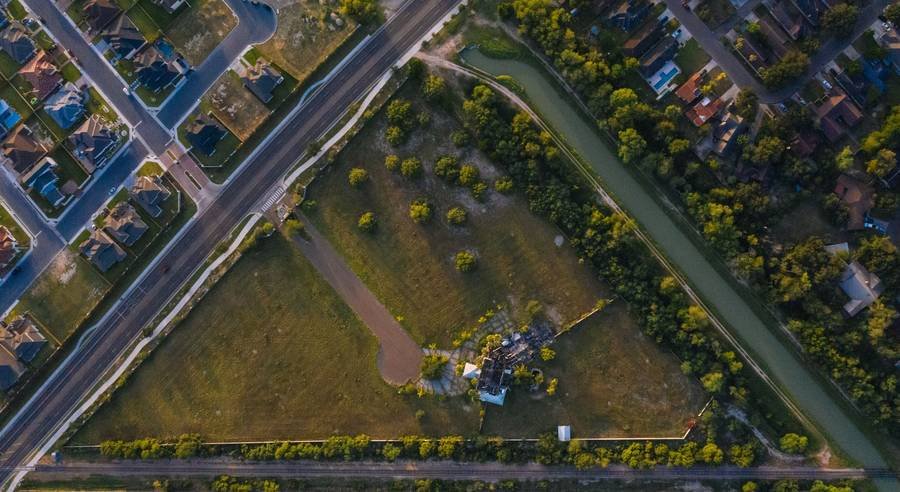 Aerial view of open lots beside a Texas neighborhood
