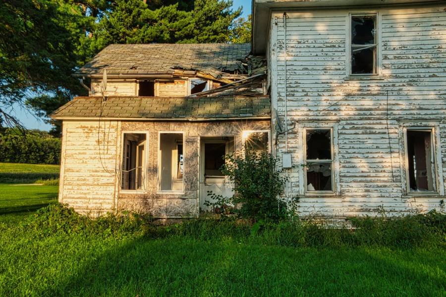 A weathered farmhouse in a field
